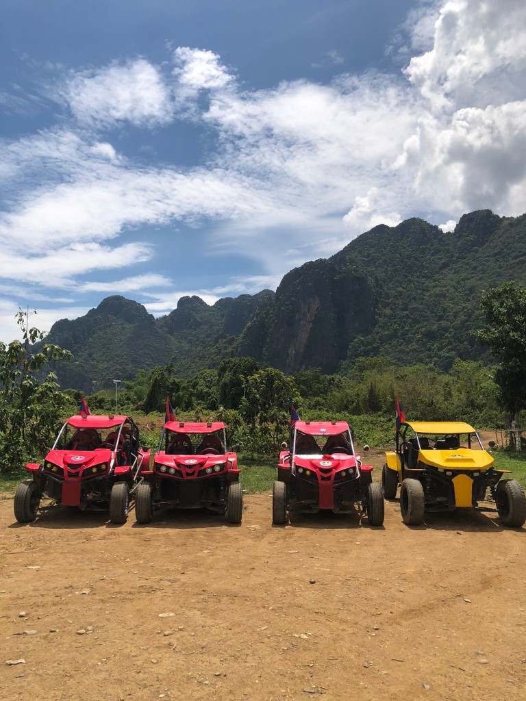 Red and yellow buggy fleet with karst mountains in Vang Vieng